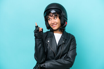 Young Argentinian woman with a motorcycle helmet isolated on blue background pointing up a great idea