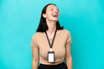 Young caucasian woman with ID card isolated on blue background laughing