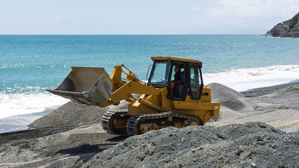 Excavator on the harbor beach for the refurbishment works