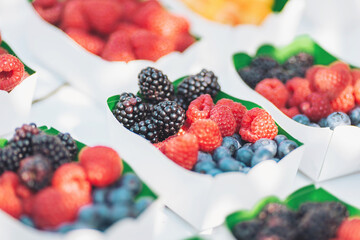 Vibrant assortment of fresh berries beautifully arranged at an outdoor market during a sunny afternoon