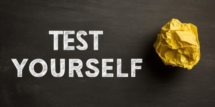 The Chalkboard Displaying 'Test Yourself' Message with Crumpled Yellow Paper Ball Nearby