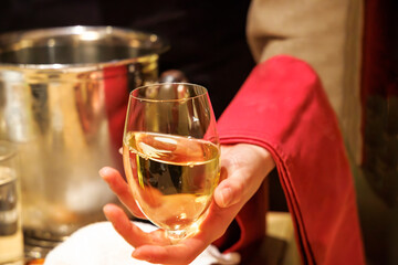 飲食店で、よく冷えた白ワインを注ぐ人