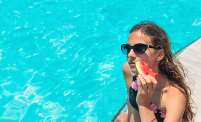 girl eating watermelon near the pool. selective focus.
