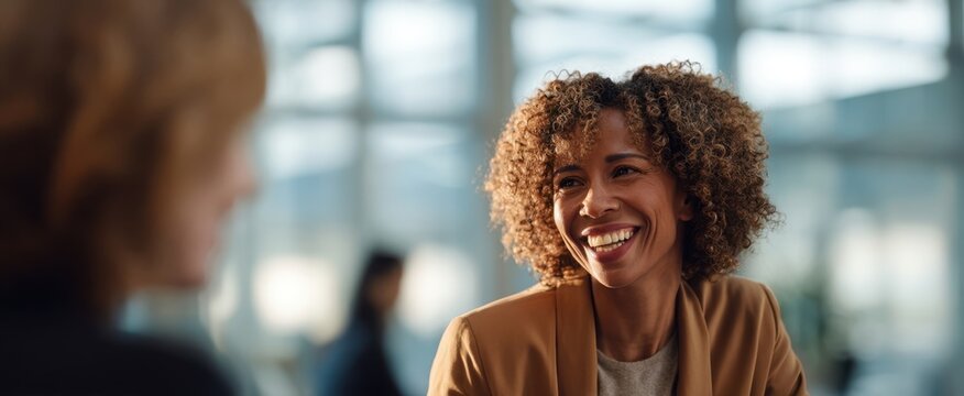 The woman smiling during a casual business conversation in a modern office setting - Powered by Adobe