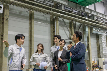 訪問者に工場を案内する作業員