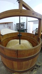 Fototapeta premium Wooden vat filled with light-colored material, possibly grain