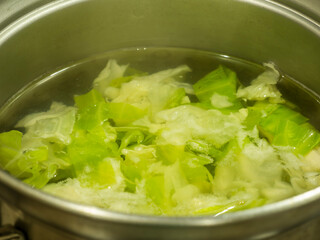 鍋で野菜を茹でているシーン。コンロ。キッチン。