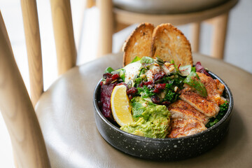 Healthy chicken salad bowl with avocado, beetroot, and toasted bread