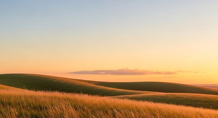 Golden hour illuminates rolling hills and dry grass under a soft gradient sky.