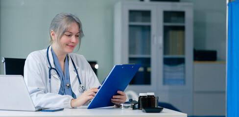 Medical Technology Concepts The doctor is working on a tablet and audio player and a digital tablet computer in a modern office in the morning at the desk.