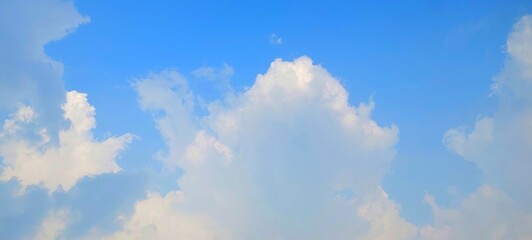 Panorama view of bright blue sky with fluffy white clouds on a clear sunny day. Sky panorama clear blue with white clouds in spring. Cloudscape