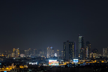 Blurred background of night lights in Bangkok. Fireworks, traffic lights, lights on bridges over the river, the spread of electric lighting technology in homes.