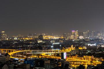 Naklejka premium Blurred background of night lights in Bangkok. Fireworks, traffic lights, lights on bridges over the river, the spread of electric lighting technology in homes.