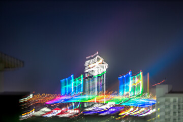Blurred background of night lights in Bangkok. Fireworks, traffic lights, lights on bridges over the river, the spread of electric lighting technology in homes.