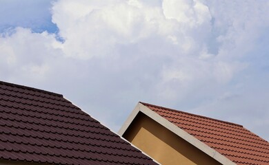 Brown and red brick zinc roof against blue sky background