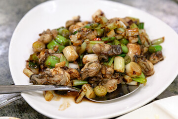 Stir-fried oysters with scallions and garlic in a savory sauce, a signature dish in Taiwanese cuisine known as three-cup oysters