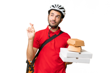 Young handsome caucasian man with thermal backpack and holding takeaway food over isolated background with fingers crossing and wishing the best