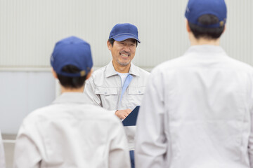 屋外でミーティングする作業員グループ