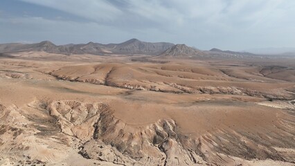 desert place where the scarce vegetation meets the mountains and the sand 