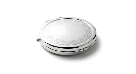 A silver, round, compact mirror with an ornate embossed pattern on its lid, isolated on a white background.