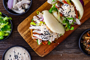 Bao Buns with pulled chicken and vegetables on wooden table