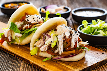 Bao Buns with pulled chicken and vegetables on wooden table