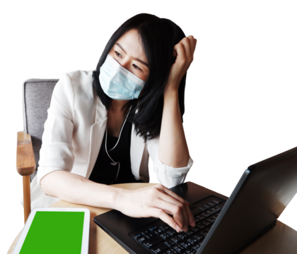 Asian businesswoman in white suit wearing mask for prevent germs and serious for working with laptop and tablet on wooden table - Powered by Adobe