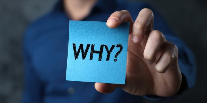 The Blue Sticky Note Asking "Why" Held by a Questioning Hand