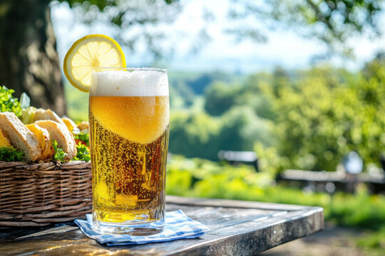 A glass of beer with a lemon slice in it sits on a table