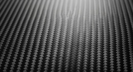 Close up of finely woven dark gray carbon fiber material texture with diagonal pattern