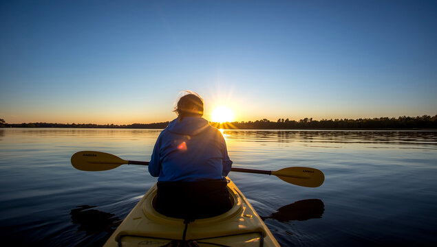Serene kayaking adventure at sunset on calm lake water for summer outdoor recreation lifestyle