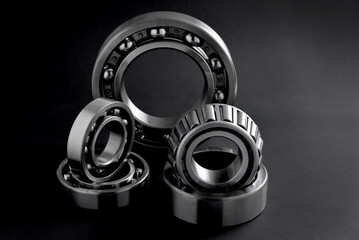 several roller bearings on black background