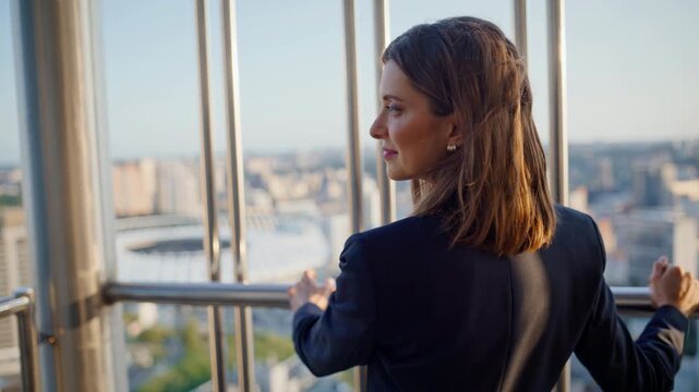 Smiling brunette contemplating cityscape standing highrise building closeup.