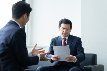 オフィスで営業を受けるミドルのビジネスマン