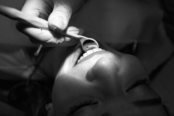 A dentist examines a patient's teeth during a routine checkup.