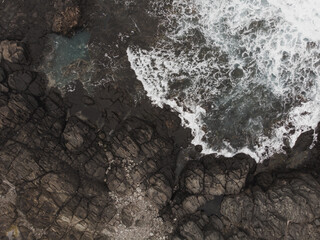 Aerial View of Rocky Coastline and Ocean Waves