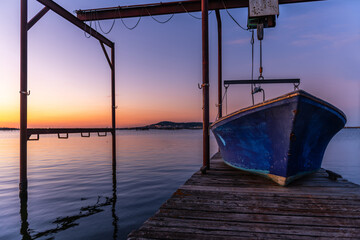 An oyster boat on a pontoon on the Thau lagoon at sunrise, in Occitanie, France