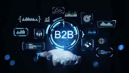 B2B digital interface with futuristic business analytics icons and graphs floating above a hand on dark background, representing digital commerce concept.