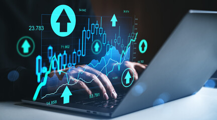 Businessman analyzing financial growth chart with laptop showing upward stock market trend concept on dark background with neon blue graphics.