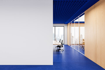 Modern office interior with blank white wall mockup, blue ceiling and floor, and wooden meeting rooms in high-rise building concept design template. 3D Rendering © ImageFlow