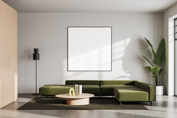 Modern living room interior with green sofa and blank poster mockup on wall in sunlight, perfect for showcasing artwork or design templates. 3D Rendering
