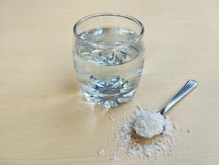 Salt water solution in glass on wooden table background, High angle view 