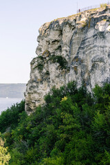 Lush green vegetation covers rocky cliffs at Bakota Bay, Ukraine, creating a breathtaking view of serene wilderness by the river.