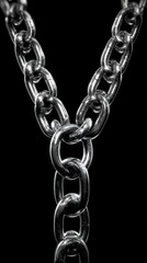 Close-up view of interconnected metal chains creating a symmetrical design against a dark background