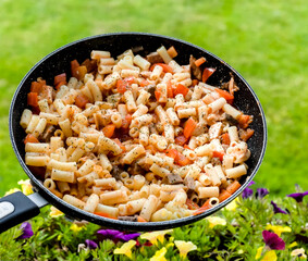 Italian Macaroni Pasta with Organic Beef, Bell Pepper, Tomato, Onion and Garlic Sauce in a Pan, Green Outdoor Garden