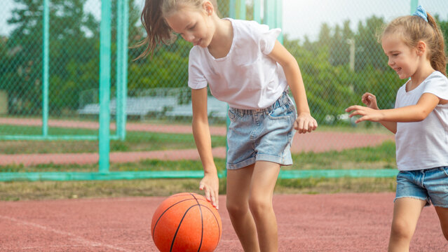 the two girl child playing basketball game on sport court - Powered by Adobe