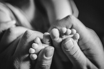 Mutter hält Babyfüße in Hand - Nähe, Geborgenheit, unendliche Liebe