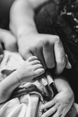 Neugeborenes Baby hält kleine Finger von seiner Mama - unendliche Mutterlieb in schwarz-weiß