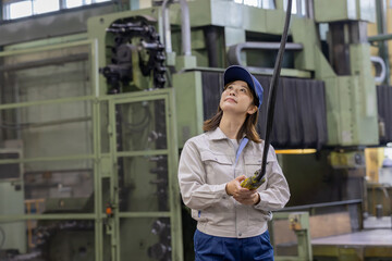 天井クレーン・玉掛けのコントローラを操作する作業員　