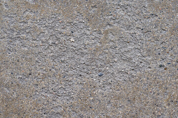 Abstract textured surface with granular elements and subtle color variations showcasing organic patterns and a rough aggregate composition in a naturalistic presentation